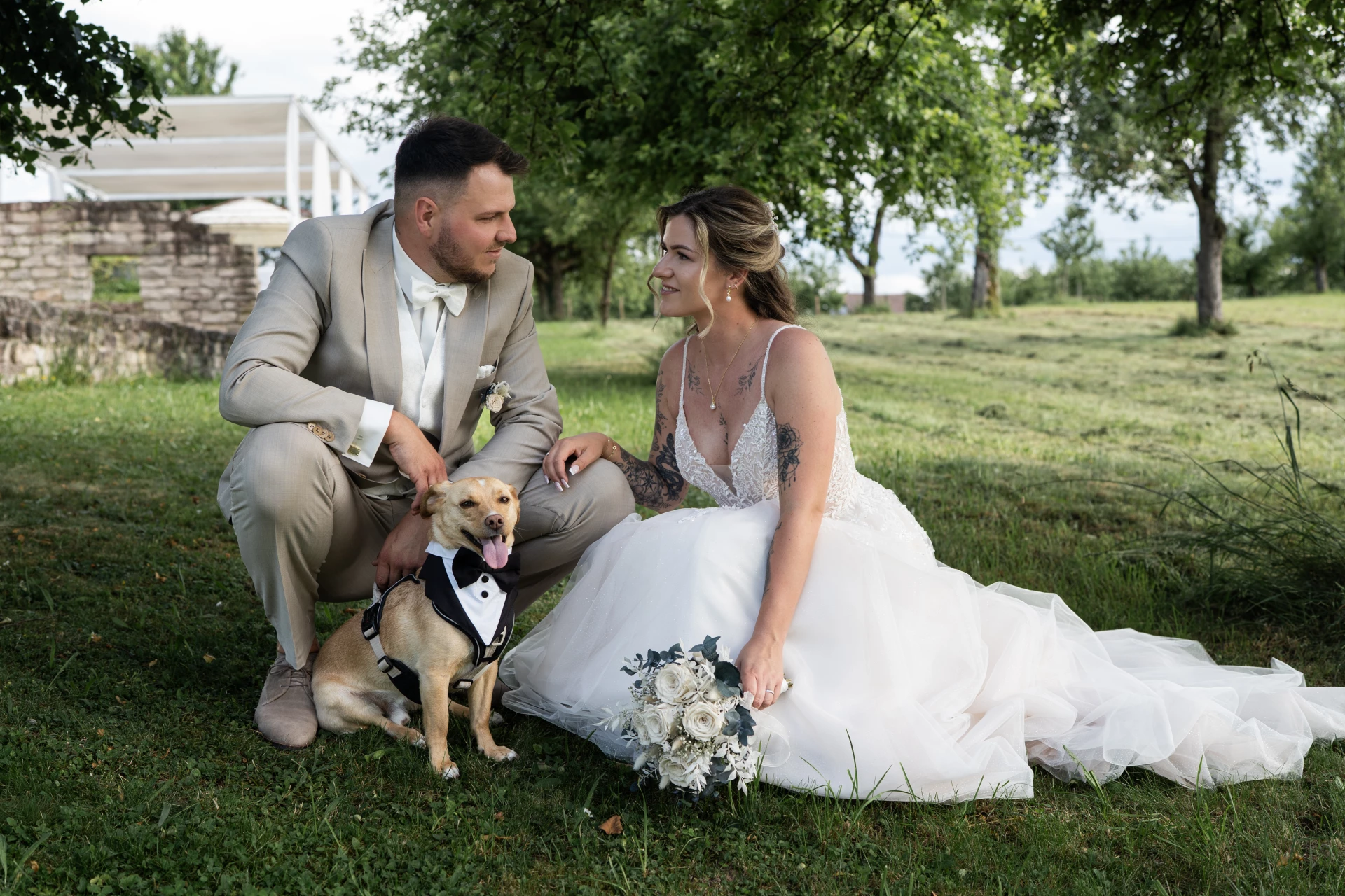 Brautpaar gemeinsam mit ihrem Hund am Hochzeitstag