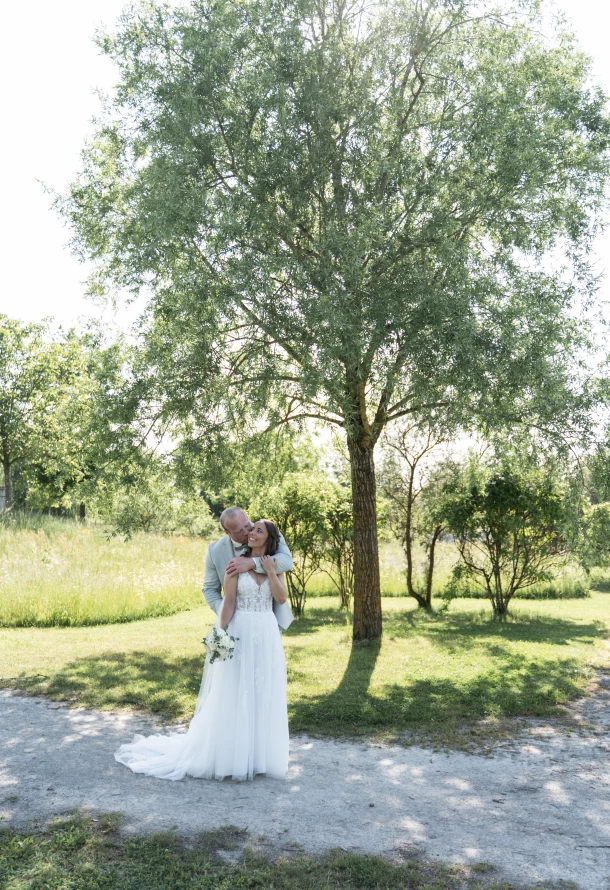 Liebevolles Brautpaar im Gegenlicht bei Sommerhochzeit