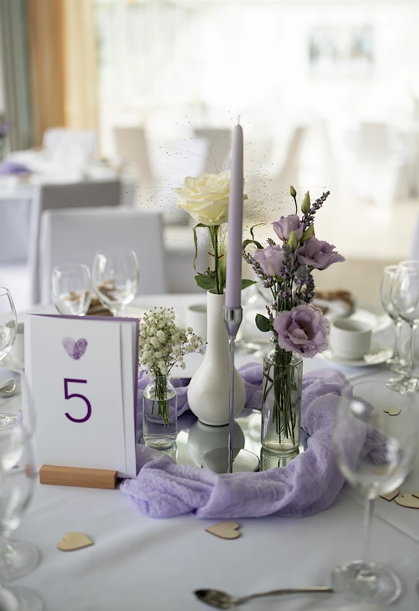 Tischdeko mit Kerzen, Blumen und farblich passender Papeterie