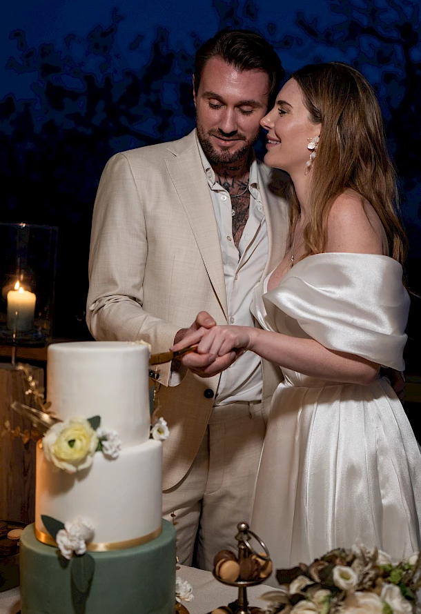 Brautpaar schneidet gemeinsam Hochzeitstorte an mit Vorfreude auf die leckere Torte
