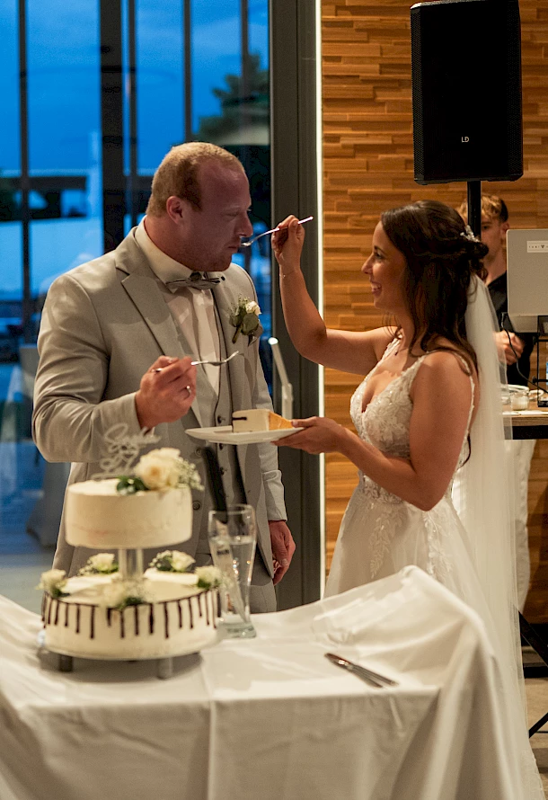 Ein Stück Hochzeitstorte mit Liebe geteilt echter Moment vom Brautpaar