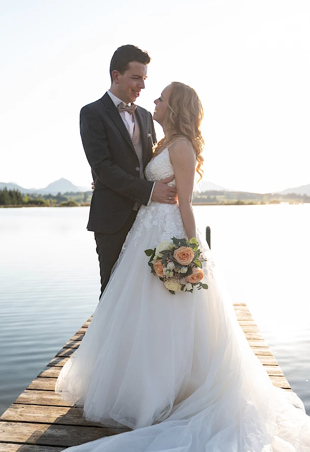 Romantisches After Wedding Shooting Brautpaar steht eng umschlungen auf einem Holzsteg