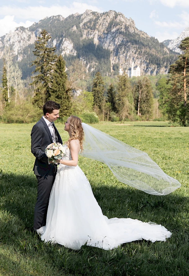 After Wedding Shooting mit liebevollen Blicken vom Brautpaar vor der Bergkulisse im Allgäu