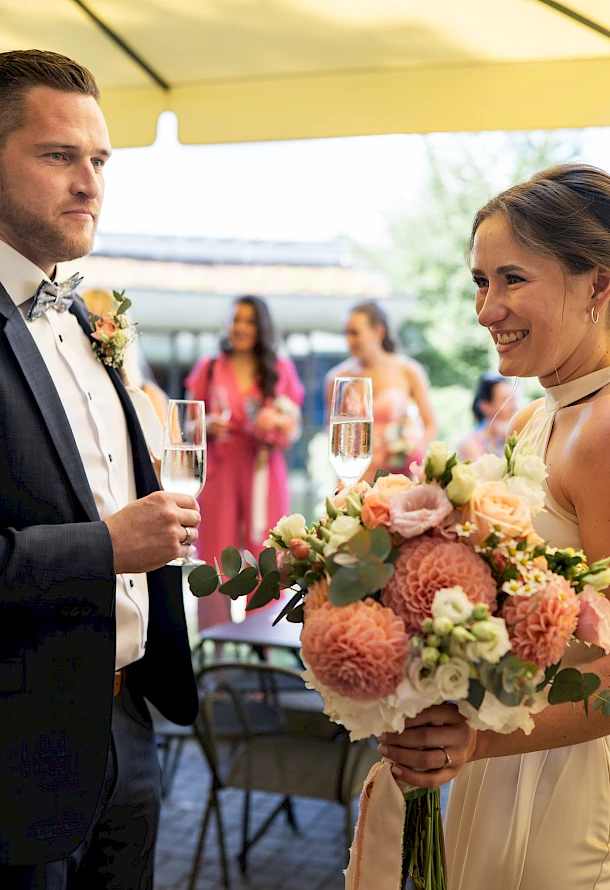 Brautpaar stößt lachend beim Sektempfang in Schwäbisch Gmünd an